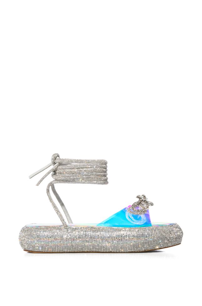 OUTSHINE EMBELLISHED BOW LACE UP FLAT SANDAL IN HOLO